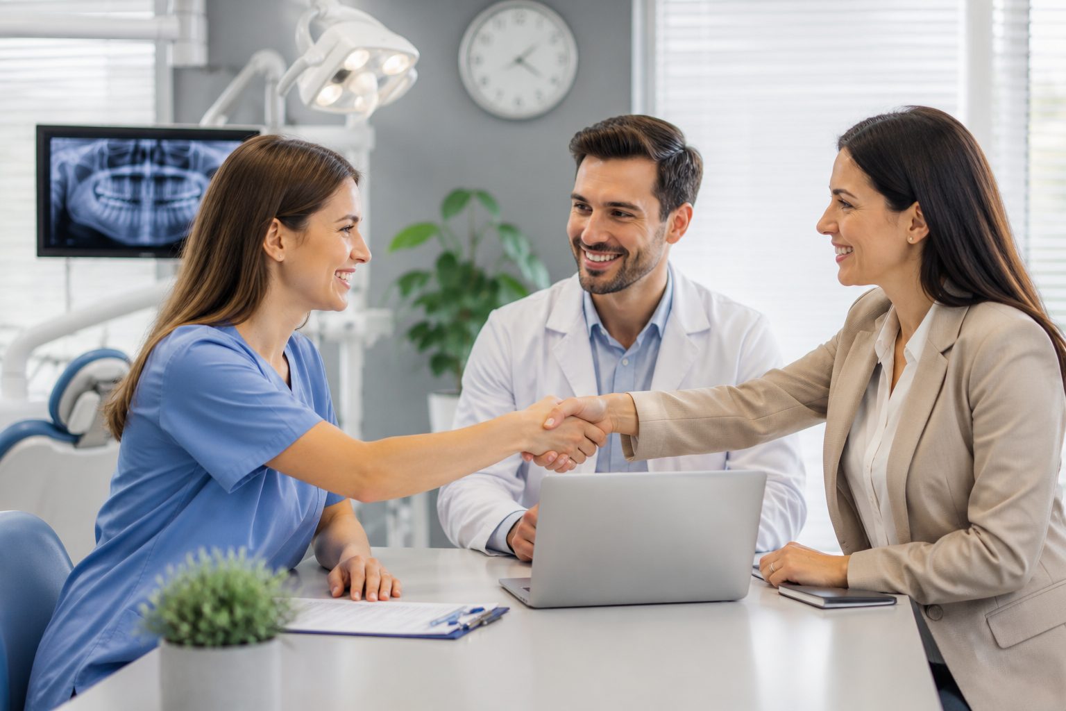 A physician and a practice administrator shaking hands across a desk after a successful introduction.